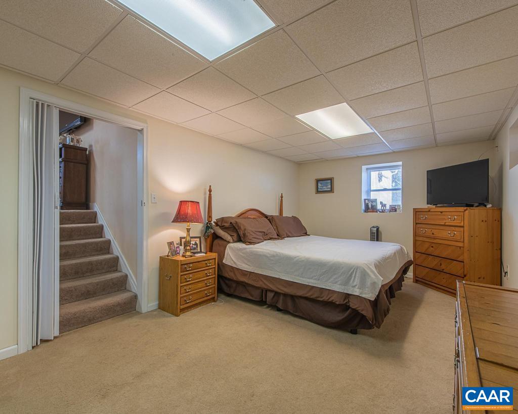 3483 West River Road Scottsville, VA 24590 - Photo 22 of 33 a spacious bedroom with a bed and a flat tv screen on dresser