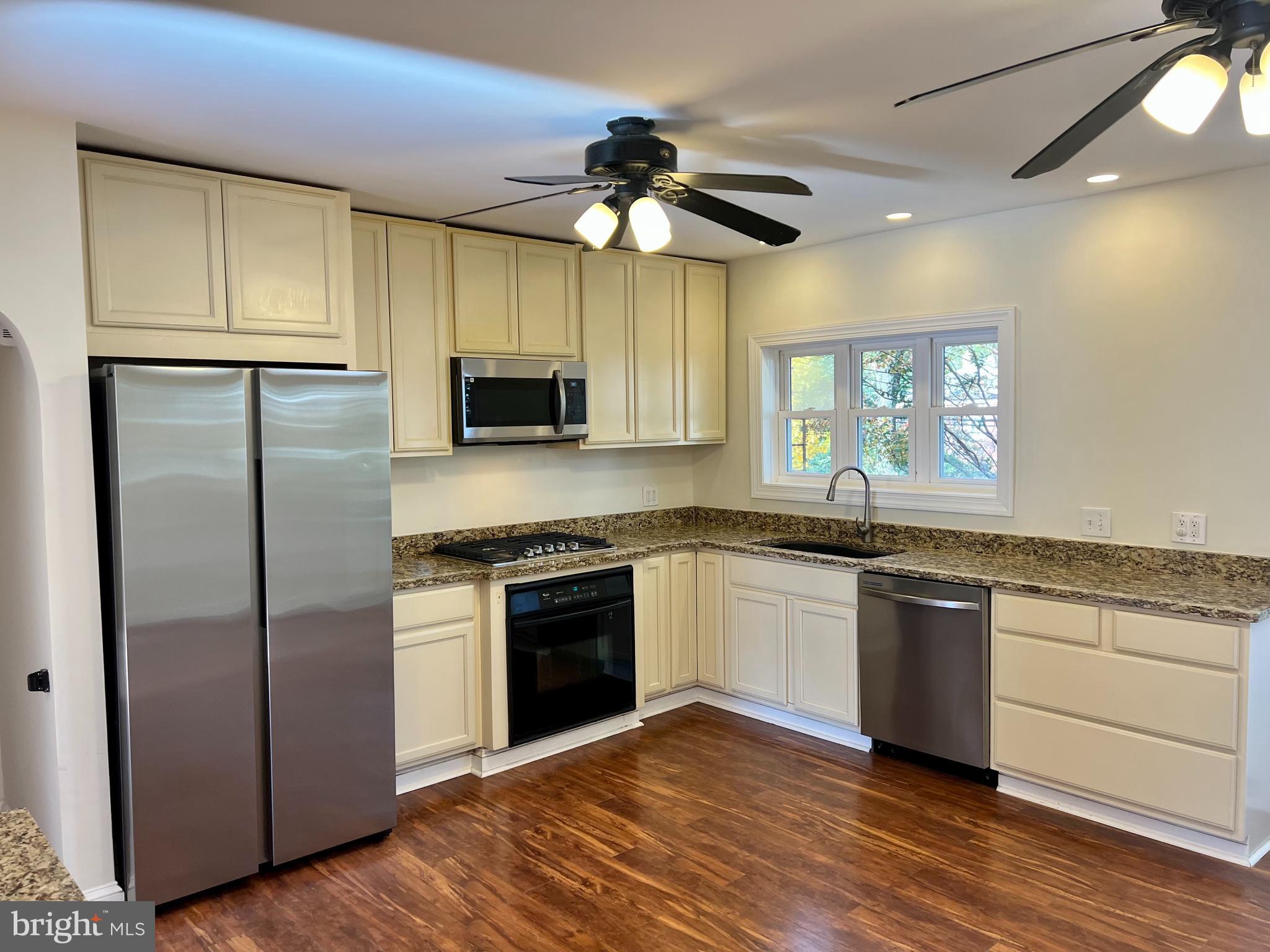 116 Murdock Road Baltimore, MD 21212 - Photo 9 of 42 a kitchen with stainless steel appliances granite countertop a refrigerator a stove a sink and white cabinets
