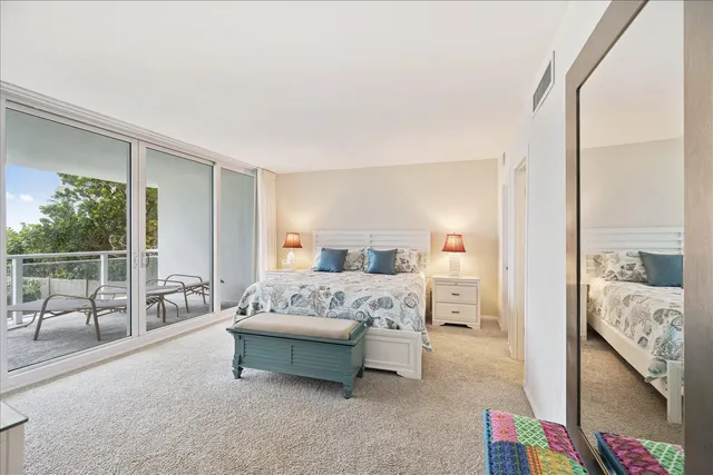 a view of a bedroom with furniture and floor to ceiling window