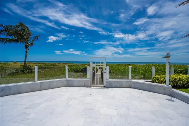 a view of a swimming pool with a garden and palm trees