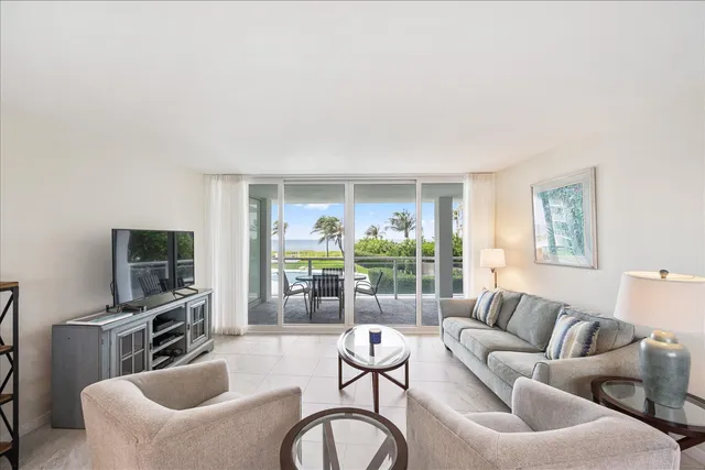 a living room with furniture a flat screen tv and a large window