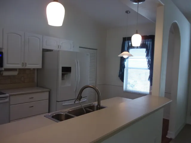 a kitchen with granite countertop white cabinets and window