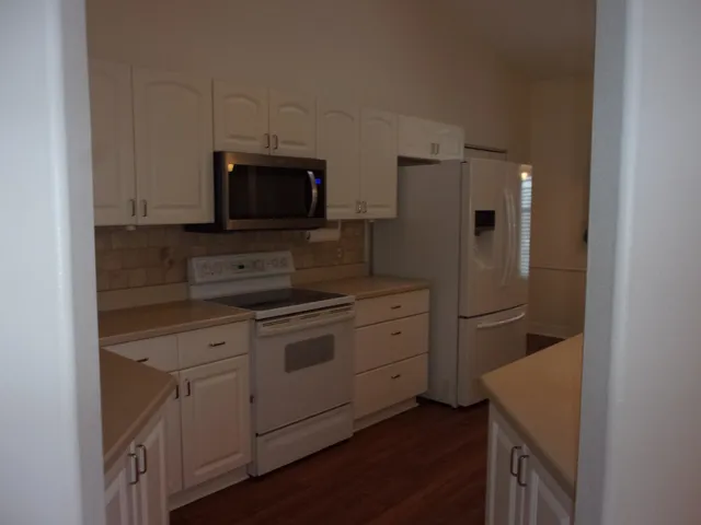 a kitchen with granite countertop white cabinets and a sink