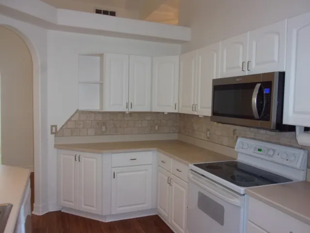a kitchen with sink a microwave and cabinets