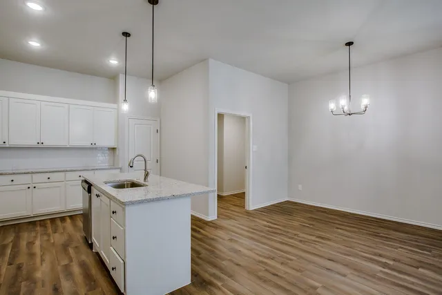 a kitchen with a sink stove and wooden floor