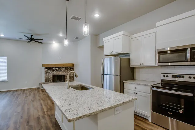 a kitchen with a appliances a refrigerator and a stove top oven