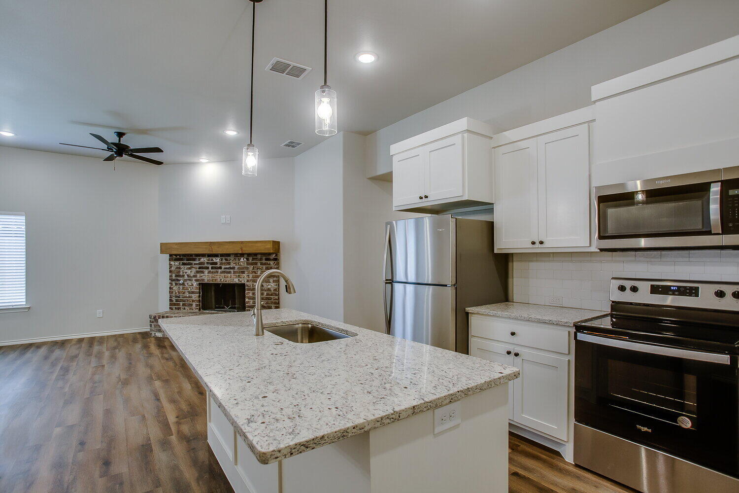 12106 Elkhart Avenue, Unit B Lubbock, TX 79424 - Photo 4 of 17 a kitchen with a appliances a refrigerator and a stove top oven