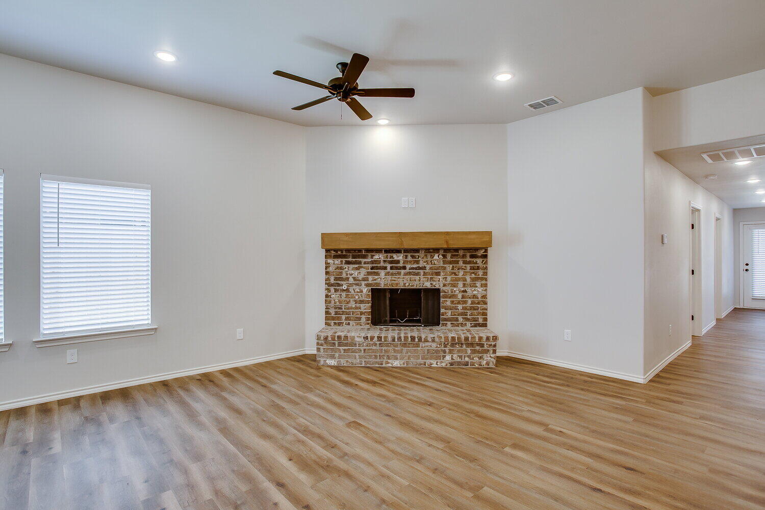 12106 Elkhart Avenue, Unit B Lubbock, TX 79424 - Photo 6 of 17 a view of an empty room with wooden floor fireplace and a window