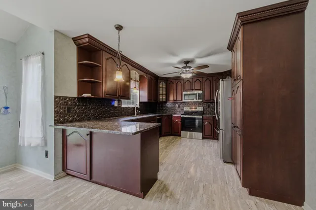 a kitchen with stainless steel appliances granite countertop a stove and a refrigerator