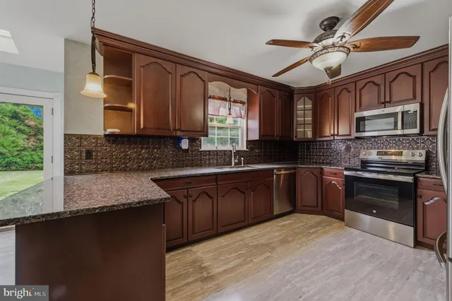 a kitchen with stainless steel appliances granite countertop a stove sink and cabinets