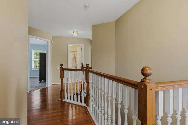 a view of a hallway with wooden floor and staircase