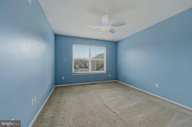 a view of an empty room with a ceiling fan