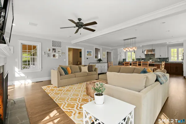 a living room with furniture kitchen view and a window