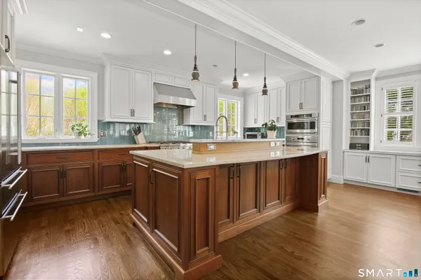 a kitchen with a sink stove cabinets and wooden floor