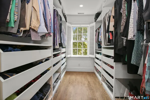 a view of walk in closet with clothes and shoes