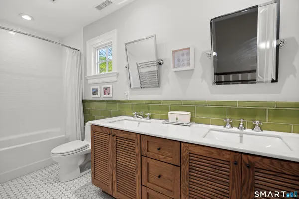 a bathroom with a toilet a sink and mirror