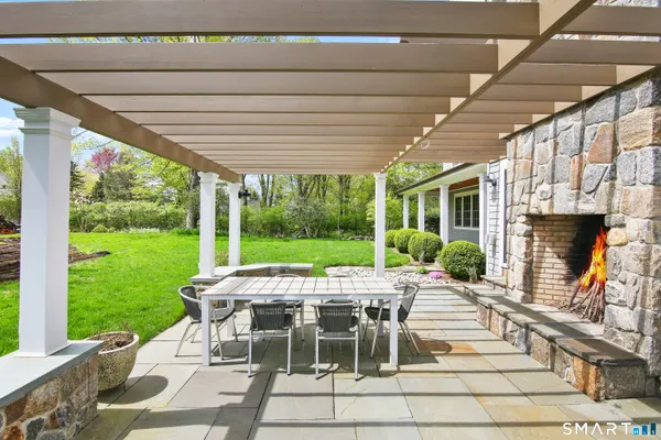 a view of a patio with a table chairs and a yard