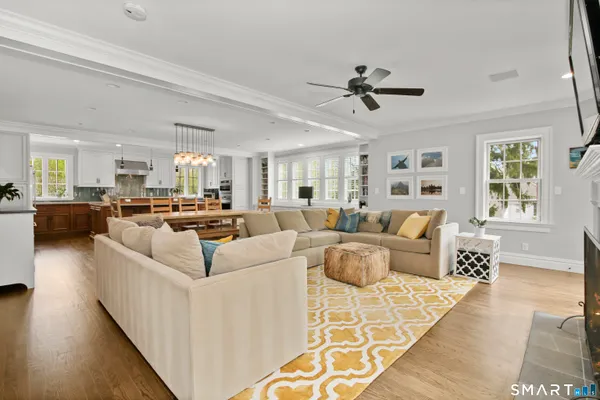 a living room with furniture kitchen view and a wooden floor
