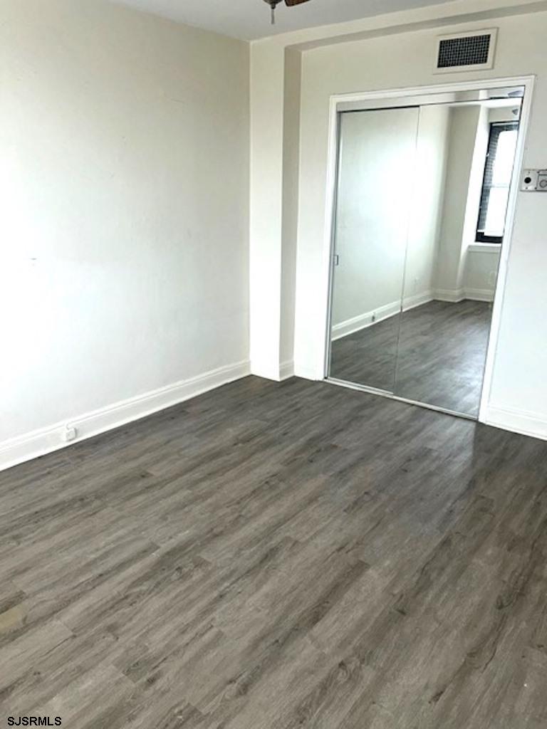 101 South Raleigh Avenue, Unit 320 Atlantic City, NJ 08401 - Photo 21 of 28 an empty room with wooden floor and mirror