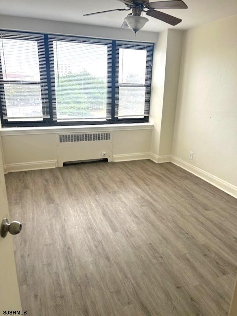 101 South Raleigh Avenue, Unit 320 Atlantic City, NJ 08401 - Photo 22 of 28 an empty room with wooden floor and windows