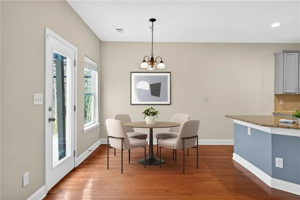 a dining room with furniture a chandelier and wooden floor