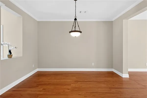 a view of a room with wooden floor air conditioner and a ceiling fan