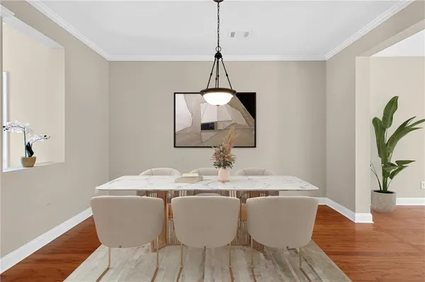a dining room with furniture potted plants and wooden floor
