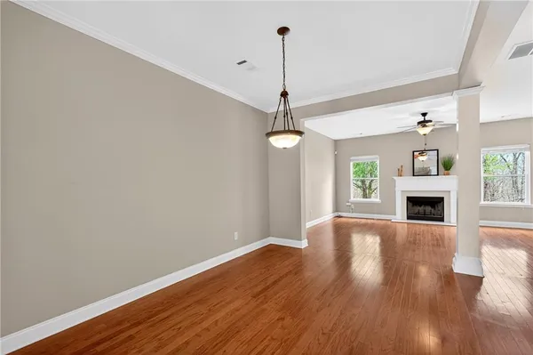 a view of a livingroom with wooden floor a fireplace and windows