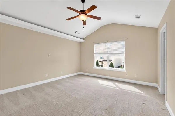an empty room with a window and a ceiling fan