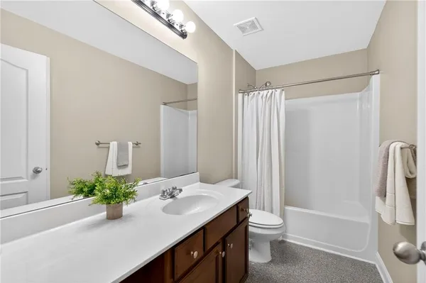 a bathroom with a double vanity sink toilet and shower
