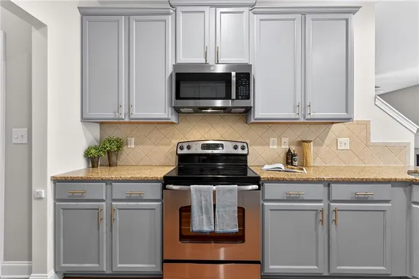 a kitchen with white cabinets and stainless steel appliances