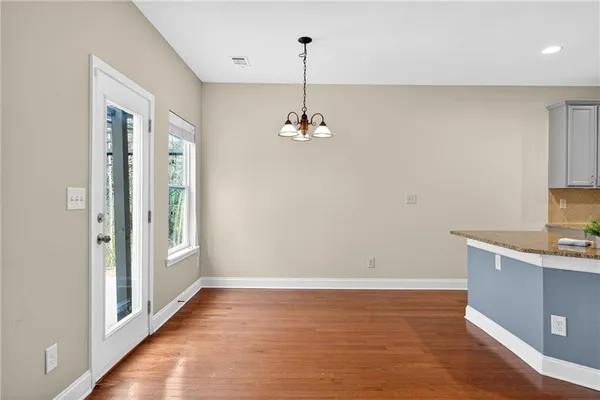 a view of a room with wooden floor and a ceiling fan