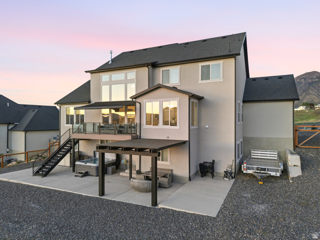 102 Elk Ridge Drive Elk Ridge, UT 84651 - Photo 52 of 61 Back of property at dusk with a patio, roof with shingles, an outdoor hangout area, and stucco siding