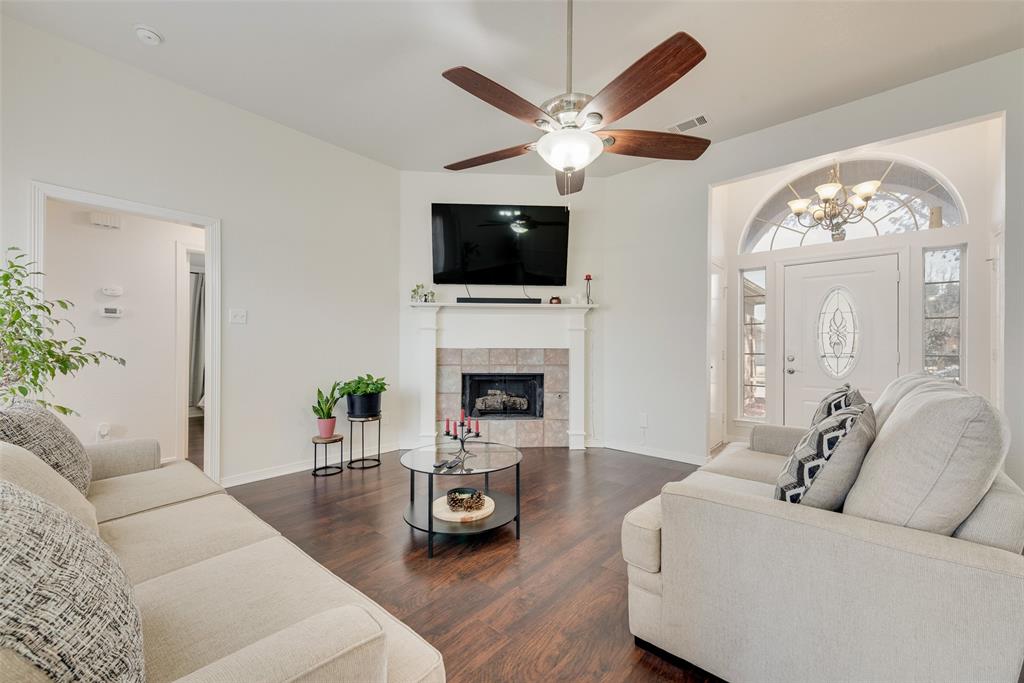 106 Villanova Circle Forney, TX 75126 - Photo 7 of 26 a living room with furniture a flat screen tv and a fireplace