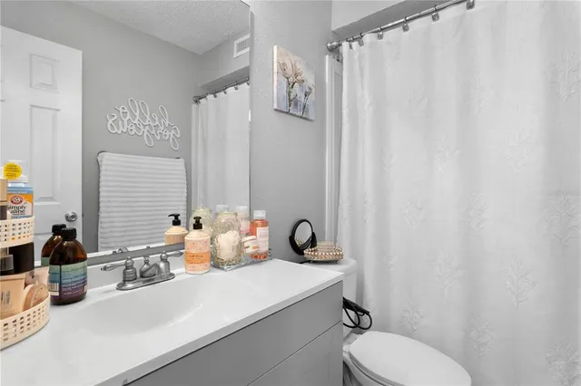 a bathroom with a toilet sink and shower curtain
