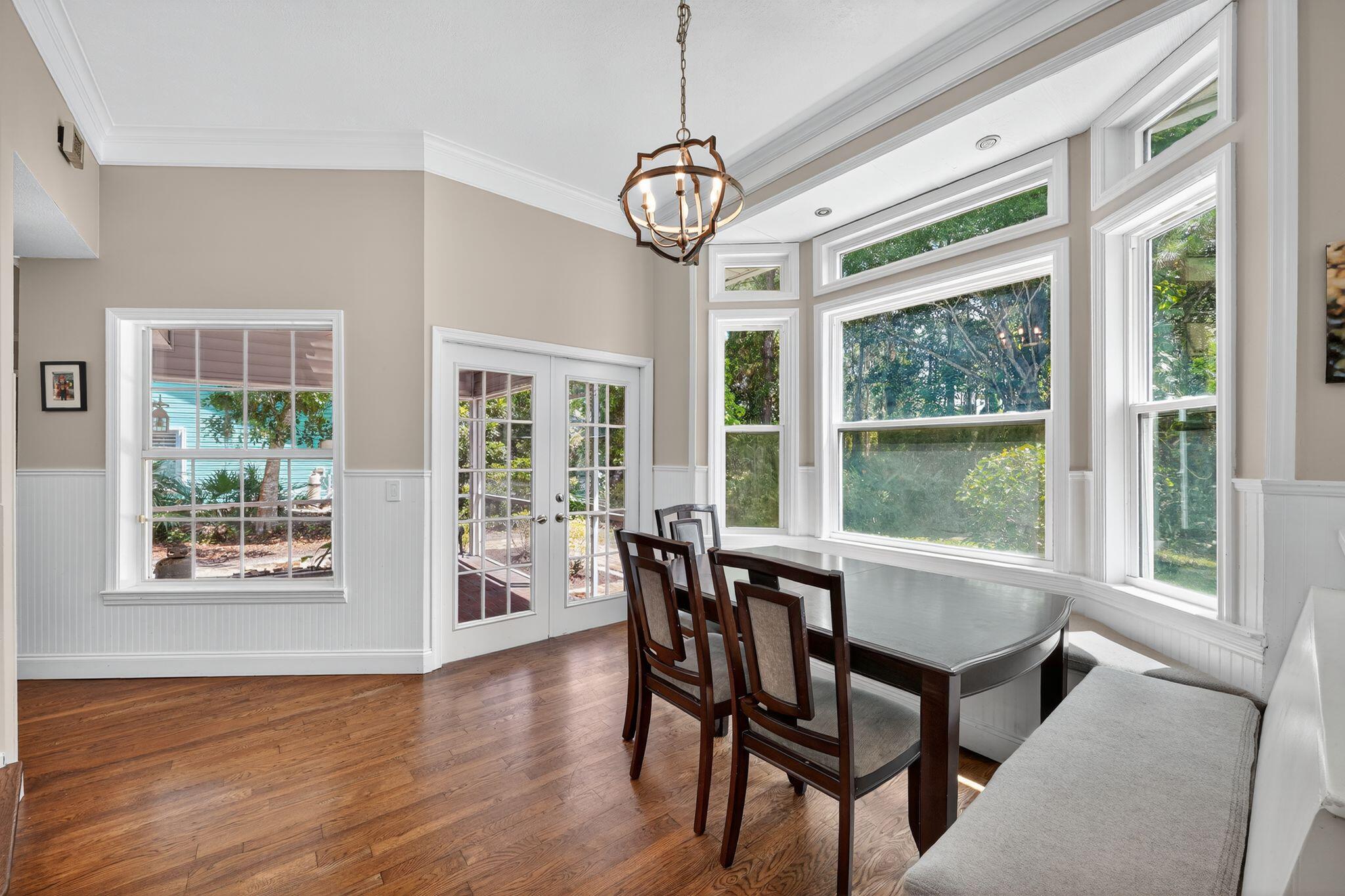 556 Meadow Wood Way Stuart, FL 34997 - Photo 14 of 57 a view of a dining room with furniture large windows and wooden floor