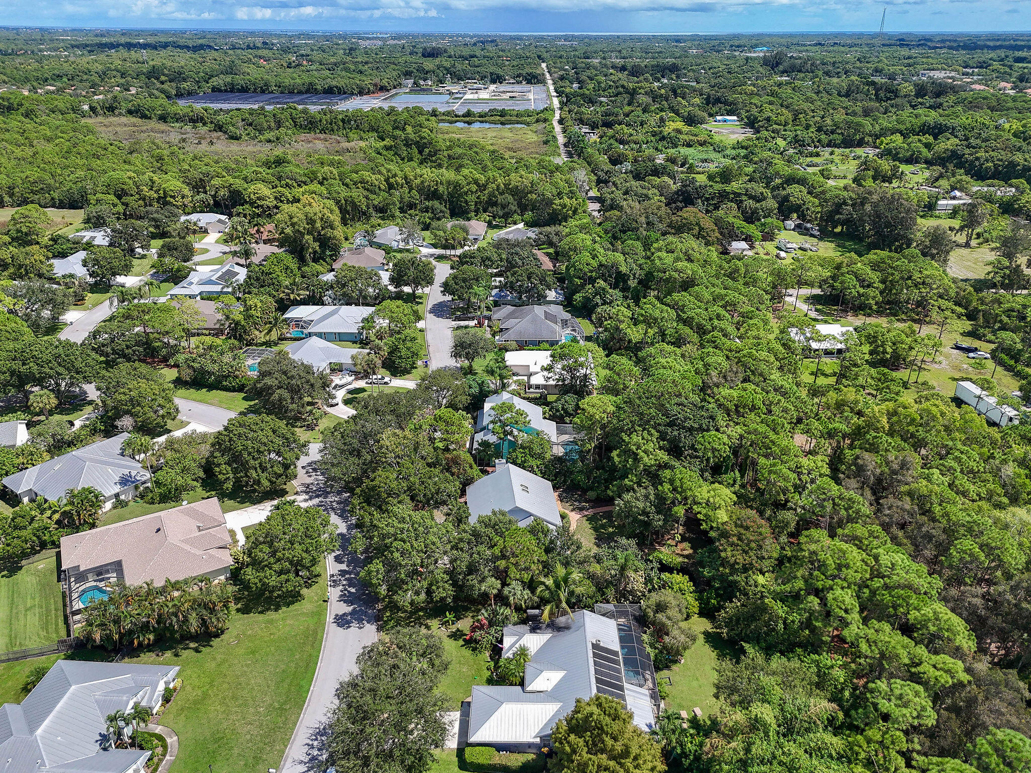 556 Meadow Wood Way Stuart, FL 34997 - Photo 38 of 57 an aerial view of residential houses with outdoor space and trees