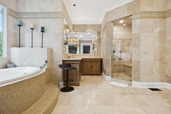 a spacious bathroom with a granite countertop sink a mirror and a bathtub