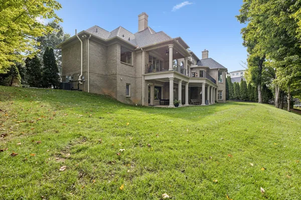 a view of a patio with table and chairs potted plants and floor to ceiling window