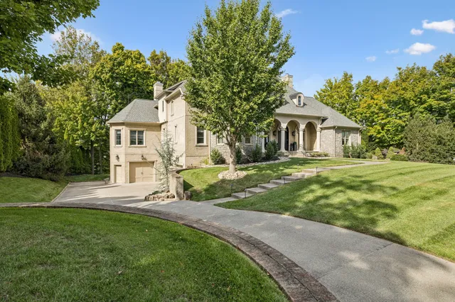 a front view of a house with a yard and trees