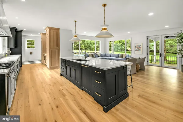 a kitchen with stainless steel appliances granite countertop a sink a stove and a wooden floors