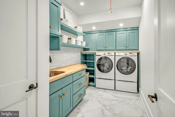 a utility room with sink dryer and washer