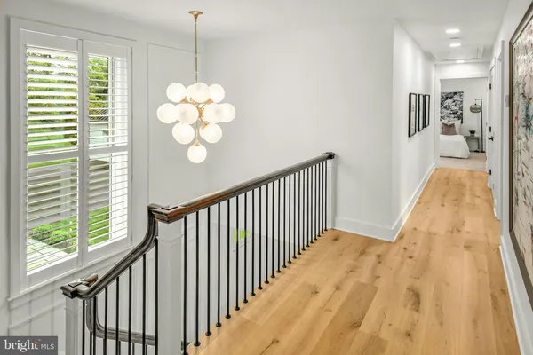 a view of a hallway with wooden floor and a chandelier