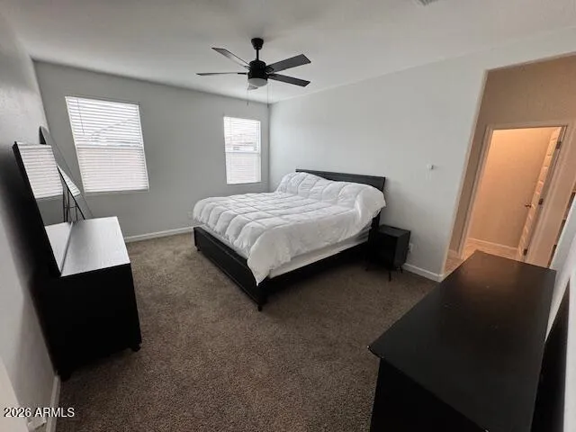 a bedroom with a bed a dresser and a window