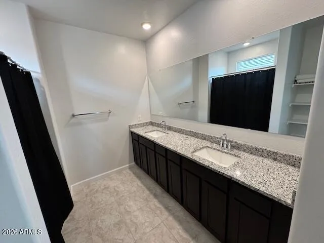 a bathroom with double sink and a mirror
