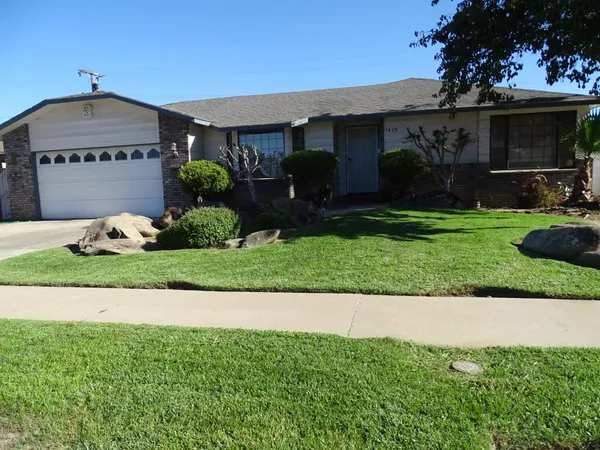 a front view of a house with a yard and a garage
