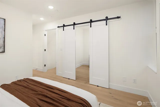 a bedroom with a bed and wooden floor