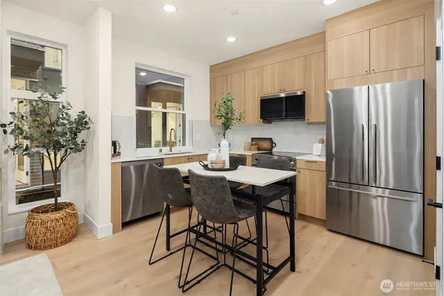 a kitchen with stainless steel appliances a refrigerator and a stove top oven