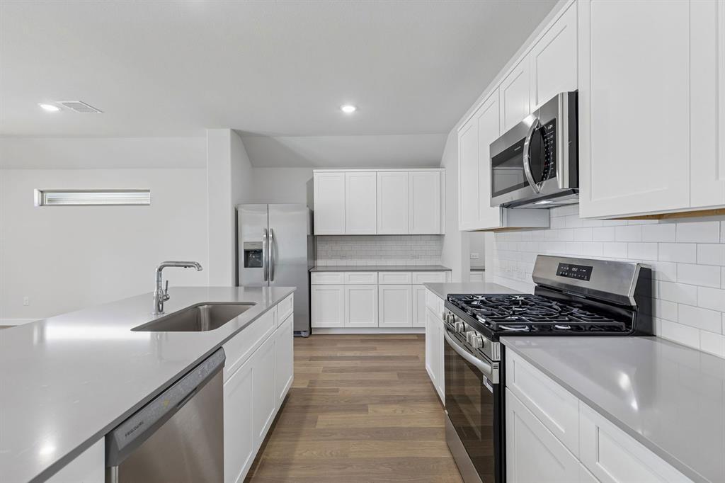 671 Sierra Ridge Lavon, TX 75166 - Photo 6 of 33 a kitchen with stainless steel appliances granite countertop a sink and a stove