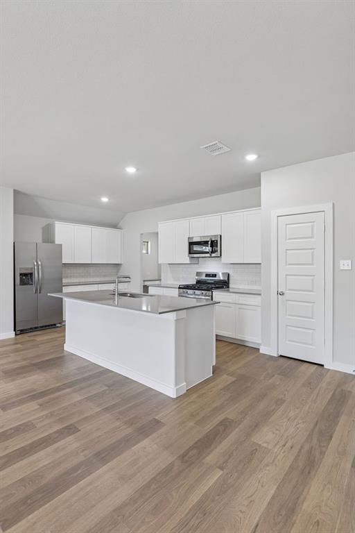 671 Sierra Ridge Lavon, TX 75166 - Photo 8 of 33 a large kitchen with kitchen island a sink stainless steel appliances and cabinets